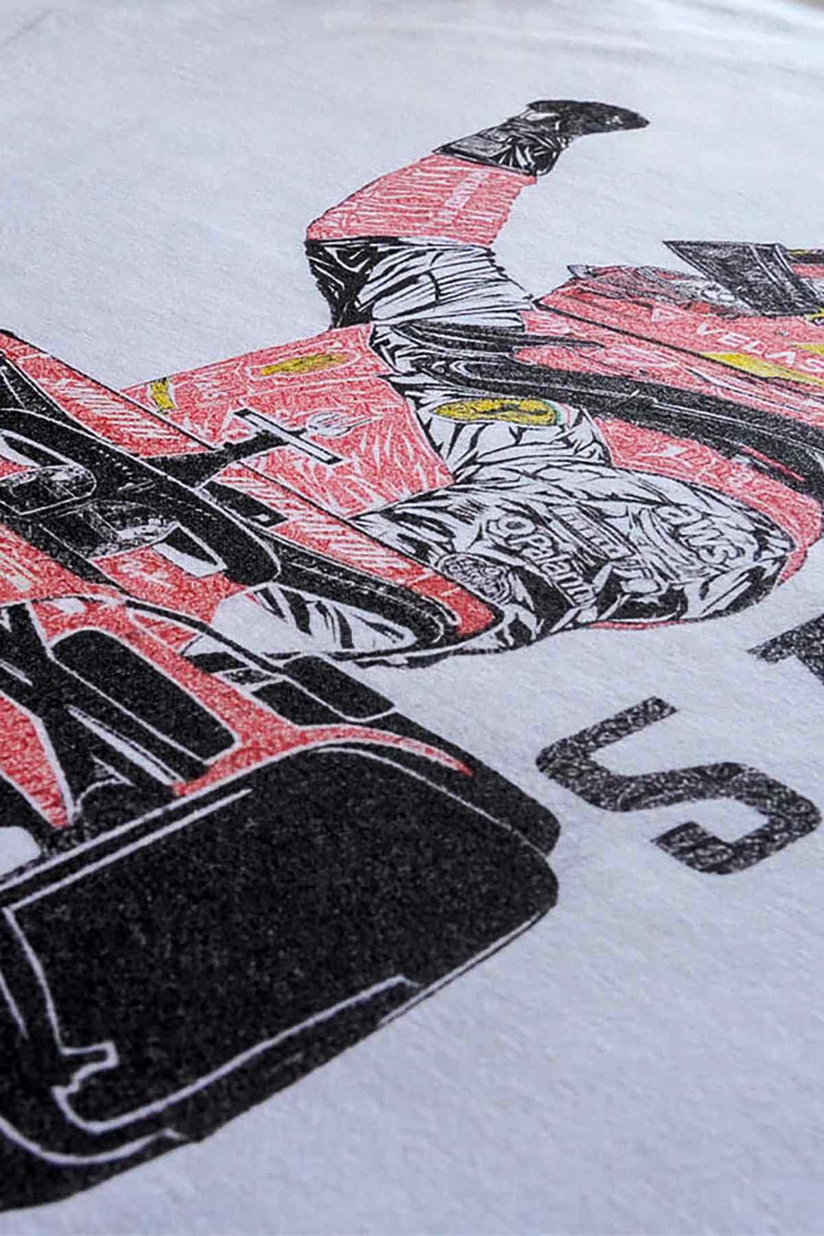 Utmost Province Carlos Sainz Ferrari T shirt laid flat on a table, highlighting the graphic design on the back of the custom Comfort Colors tshirt.