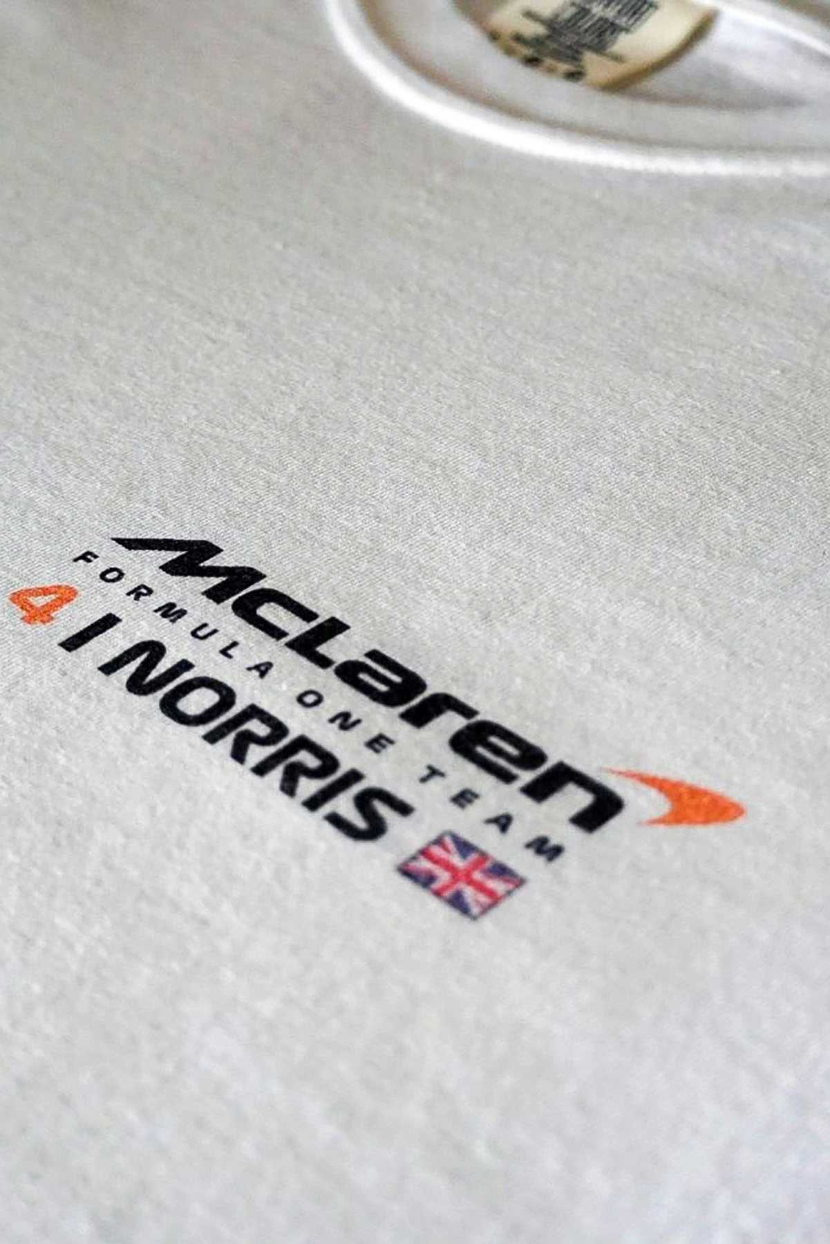 Utmost Province Mclaren F1 shirt inspired by Lando Norris, highlighting the graphic desgn on the front left chest of the unisex cotton t shirt.