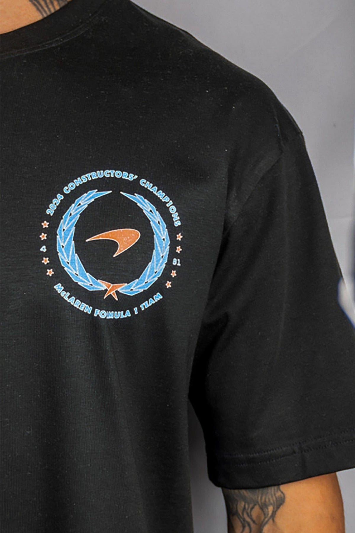 Close up of a person wearing a black custom Mclaren F1 shirt designed by Utmost Province.