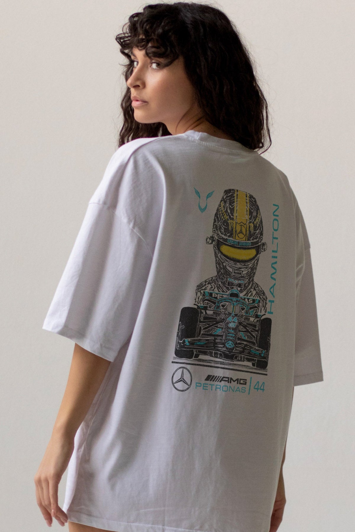 Person wearing a white t-shirt with a graphic design on the back, featuring a Lewis Hamilton in Mercedes racing gear.
