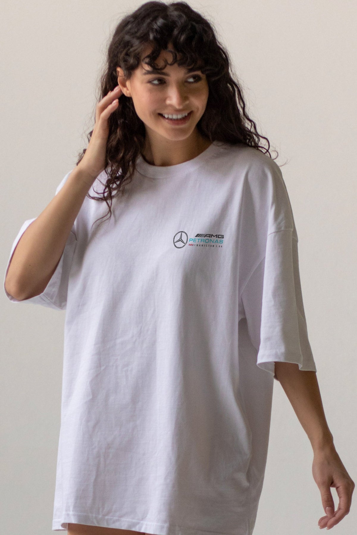 Woman wearing a white t-shirt with a custom Mercedes F1 logo on the front.