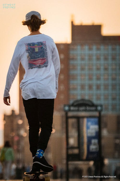 Model on a skateboard, wearing a long sleeve t-shirt, showcasing Utmost Province's Men's F1 merch collection.