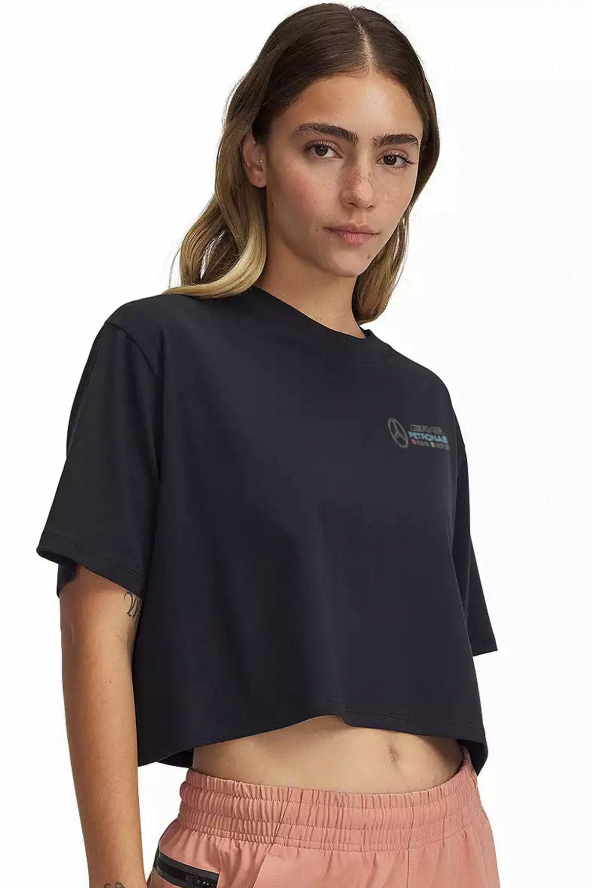 Person wearing a black custom Mercedes F1 crop top, showcasing the front graphic design.