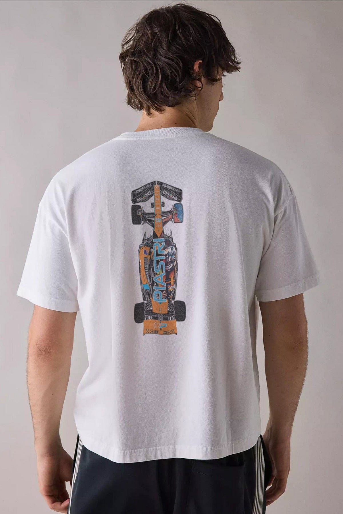 Person wearing Utmost Province's custom Oscar Piastri F1 Mclaren T Shirt, showcasing the back design on the graphic tee.