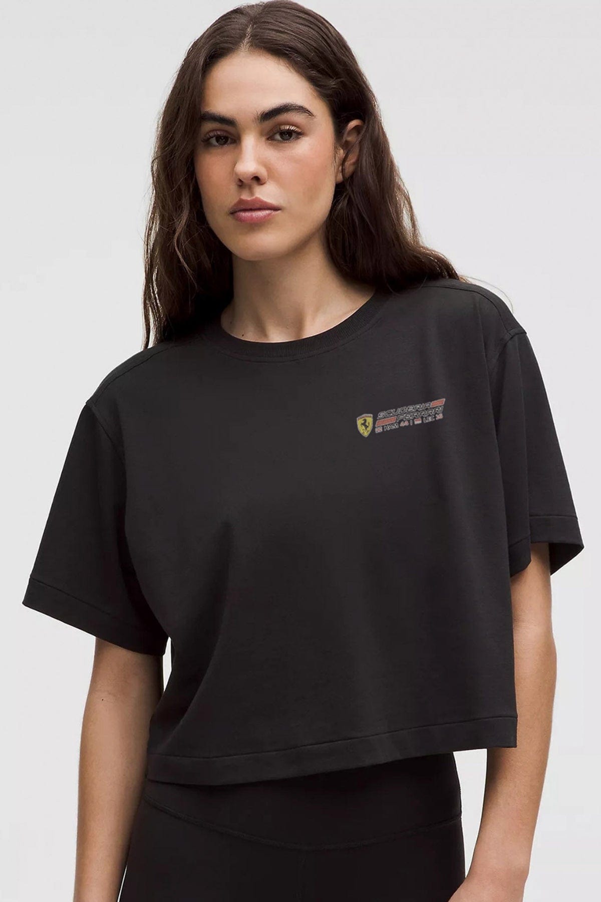 Person wearing a black cropped tee, showcasing the front graphic design.