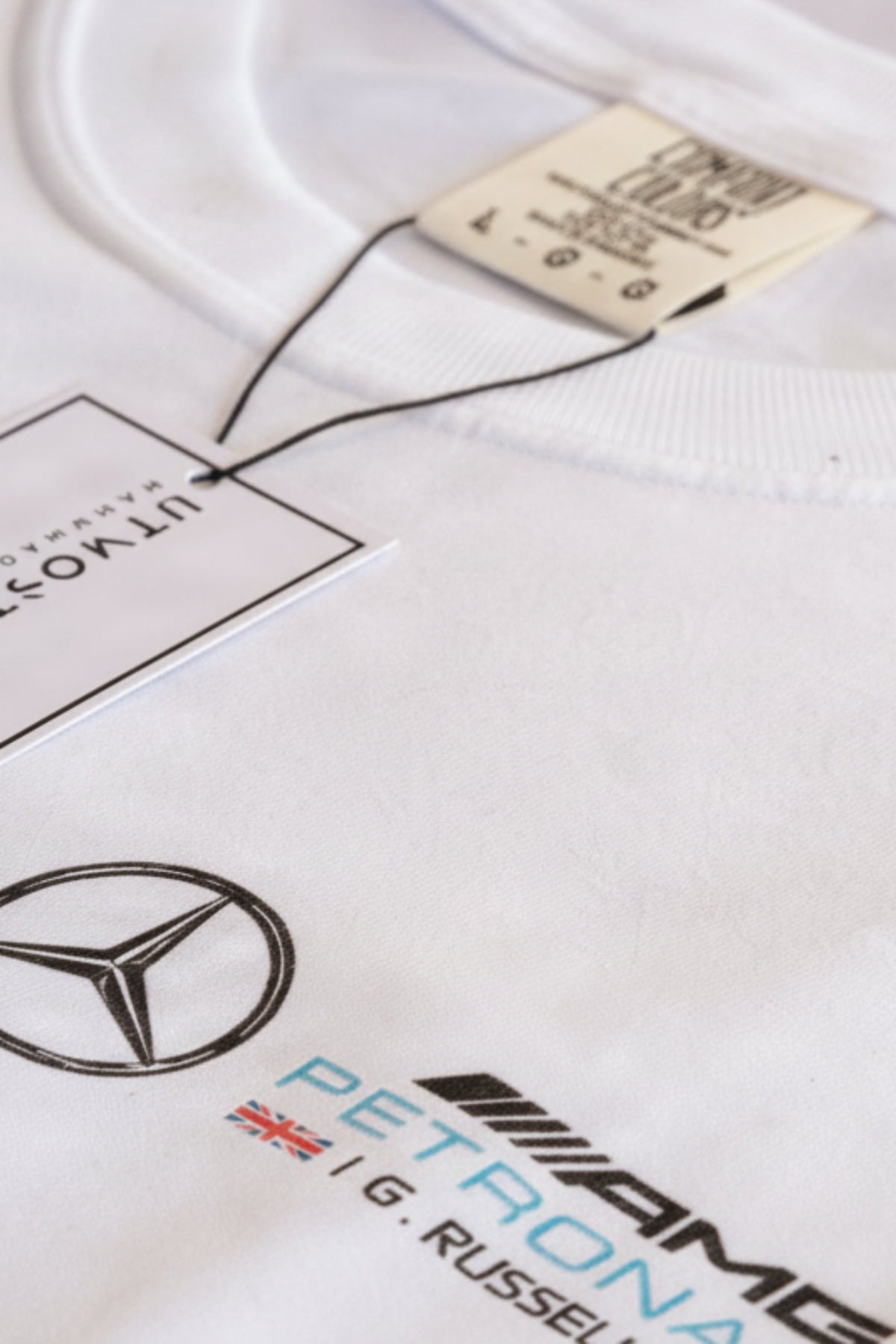 Close up view of the front of Utmost Province George Russell shirt, highlighting the front left chest design. 