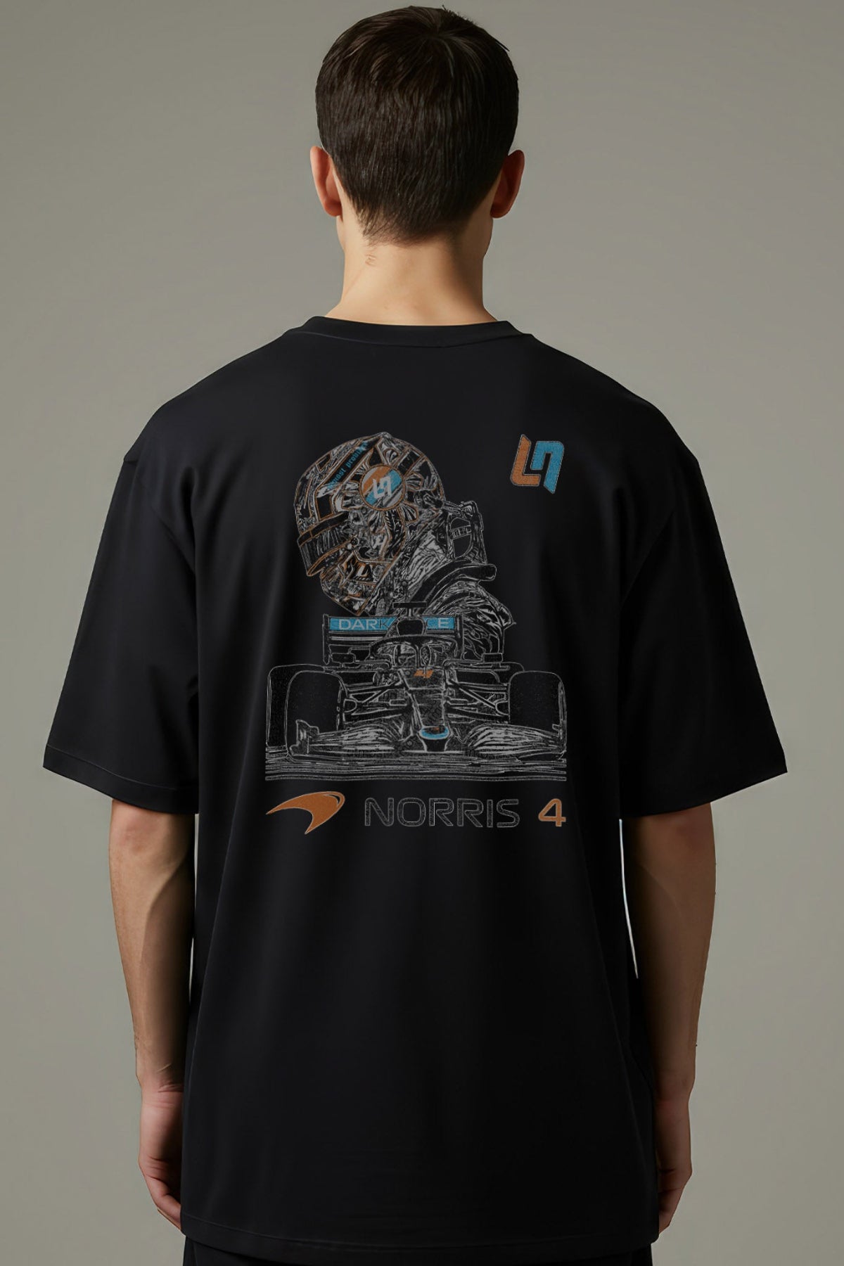 Man  wearing a black F1 Mclaren t shirt, showcasing the design printed on the back of the Comfort Colors shirt.