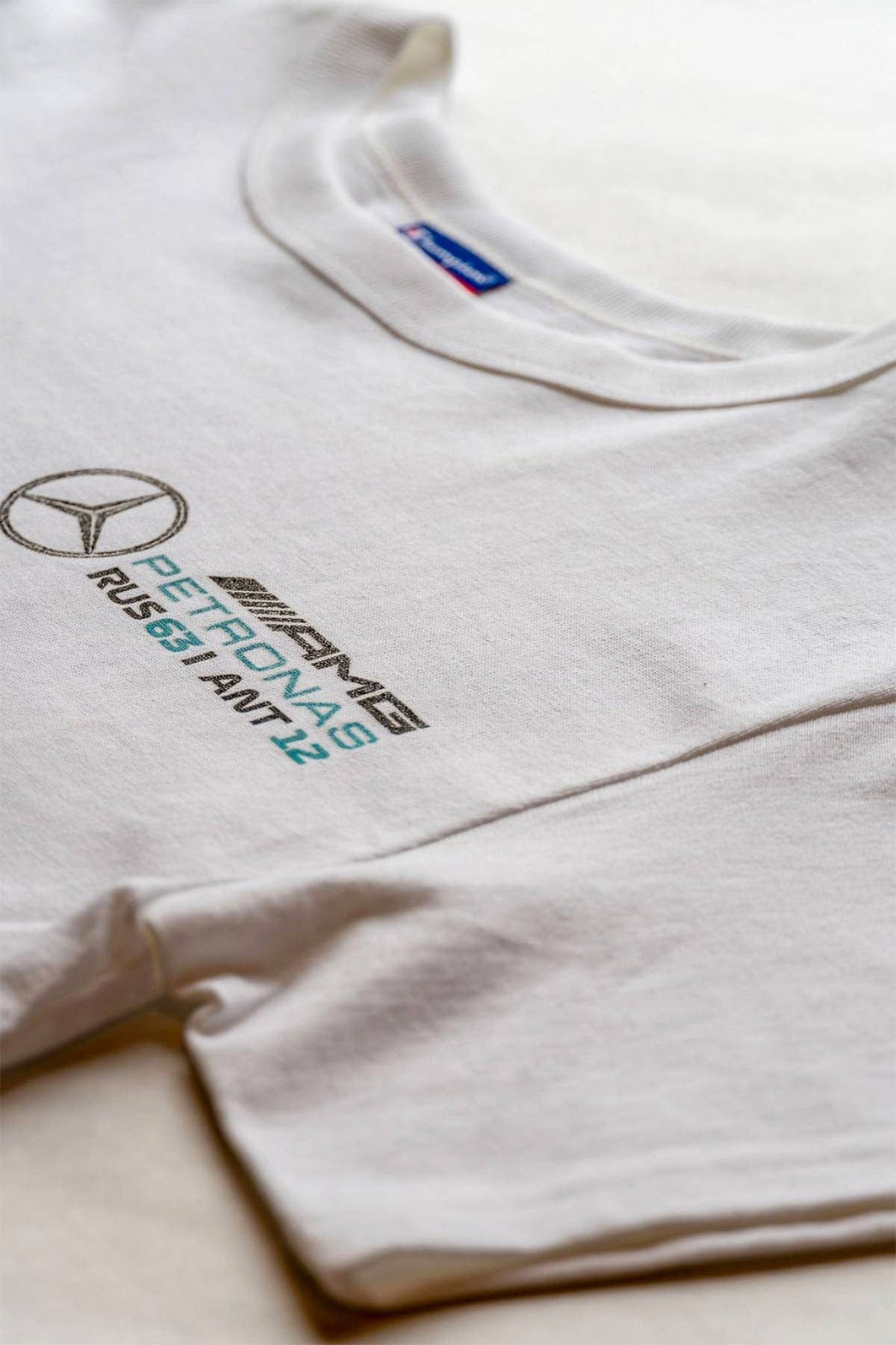 Close up of a white crop top shirt, featuring a custom Mercedes F1 logo.