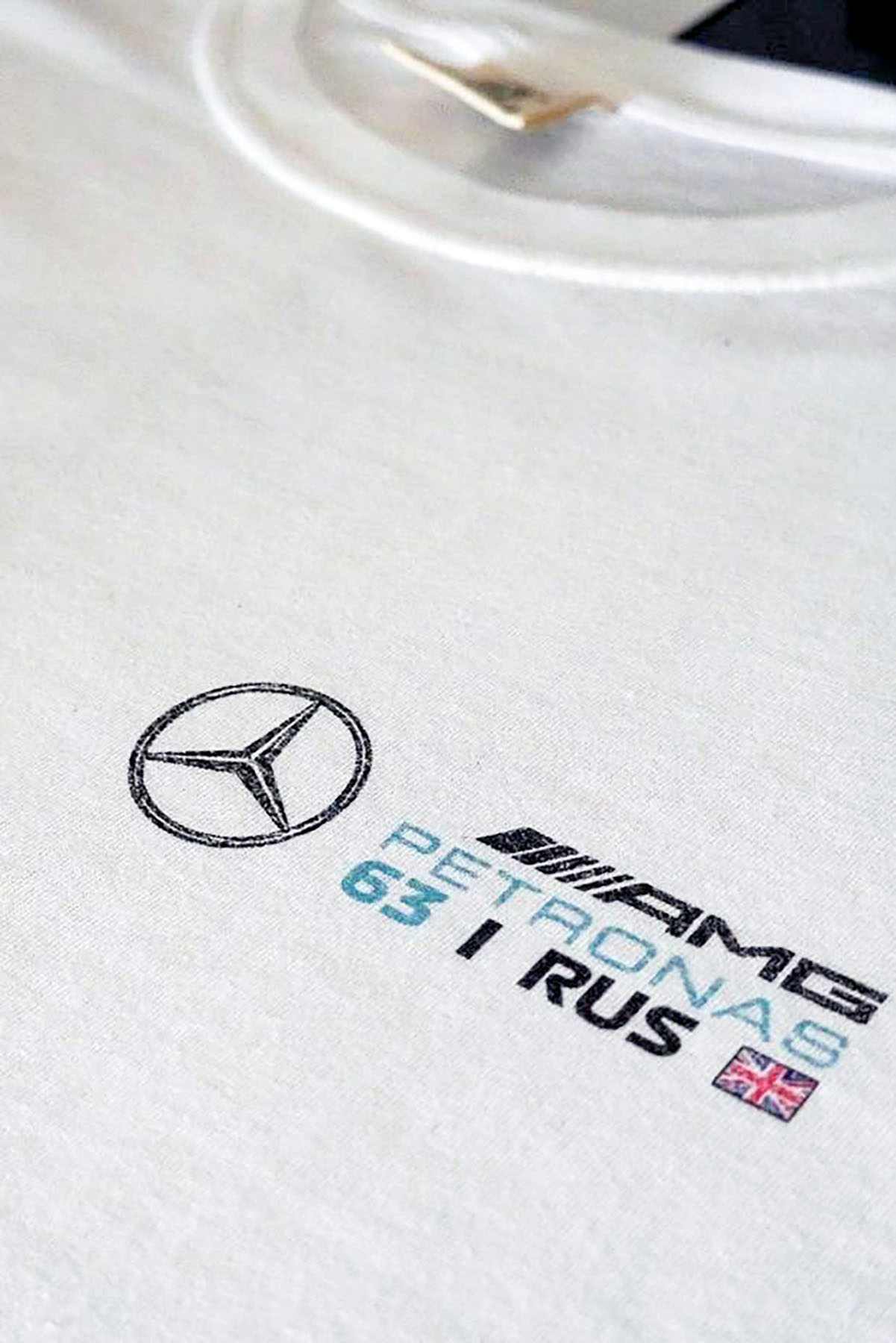 Utmost Province Mercedes F1 race car t shirt laid flat on a table, highlighting the front left chest graphic design.