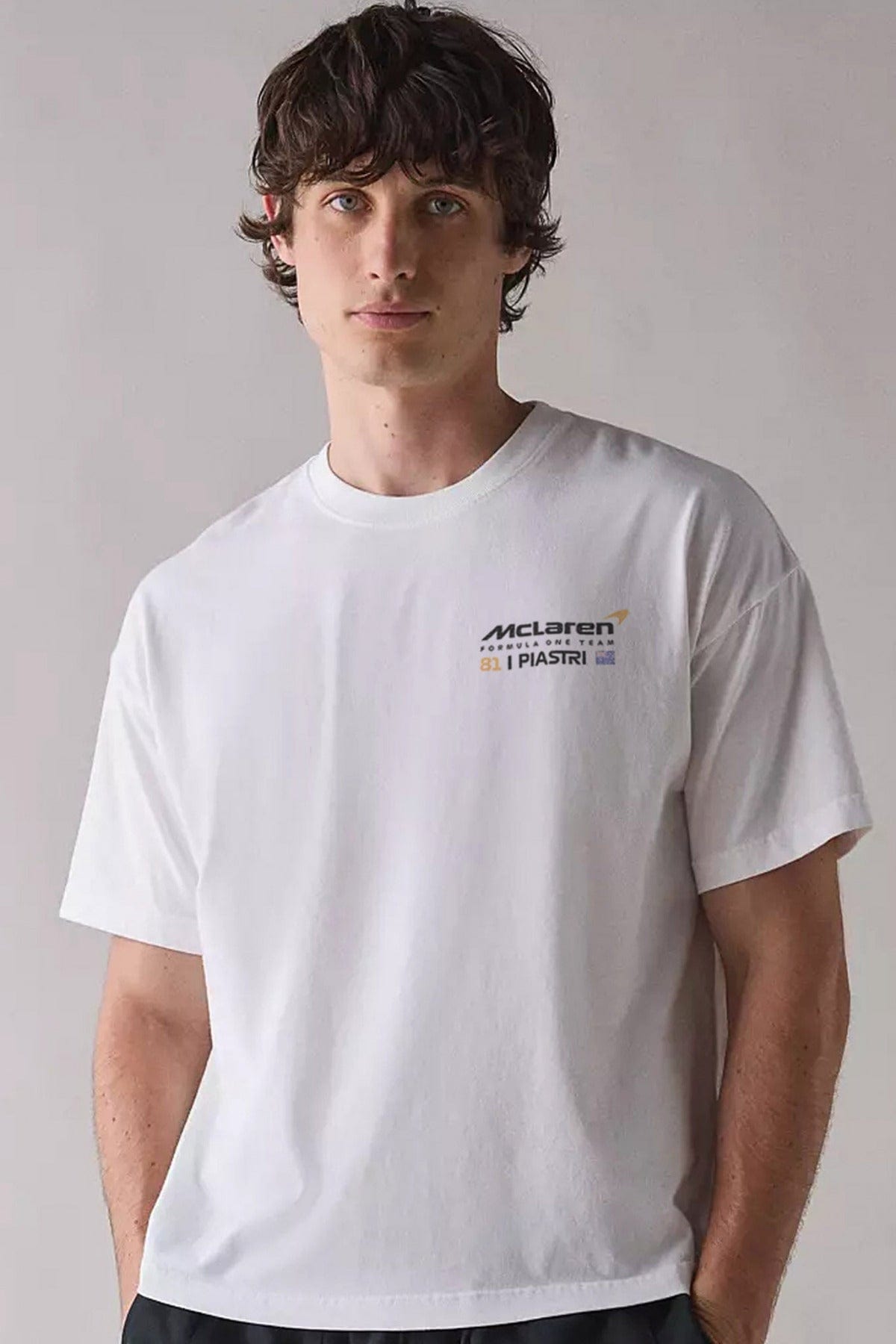 Person wearing a white t-shirt with a custom F1 Mclaren logo on the front of the shirt.