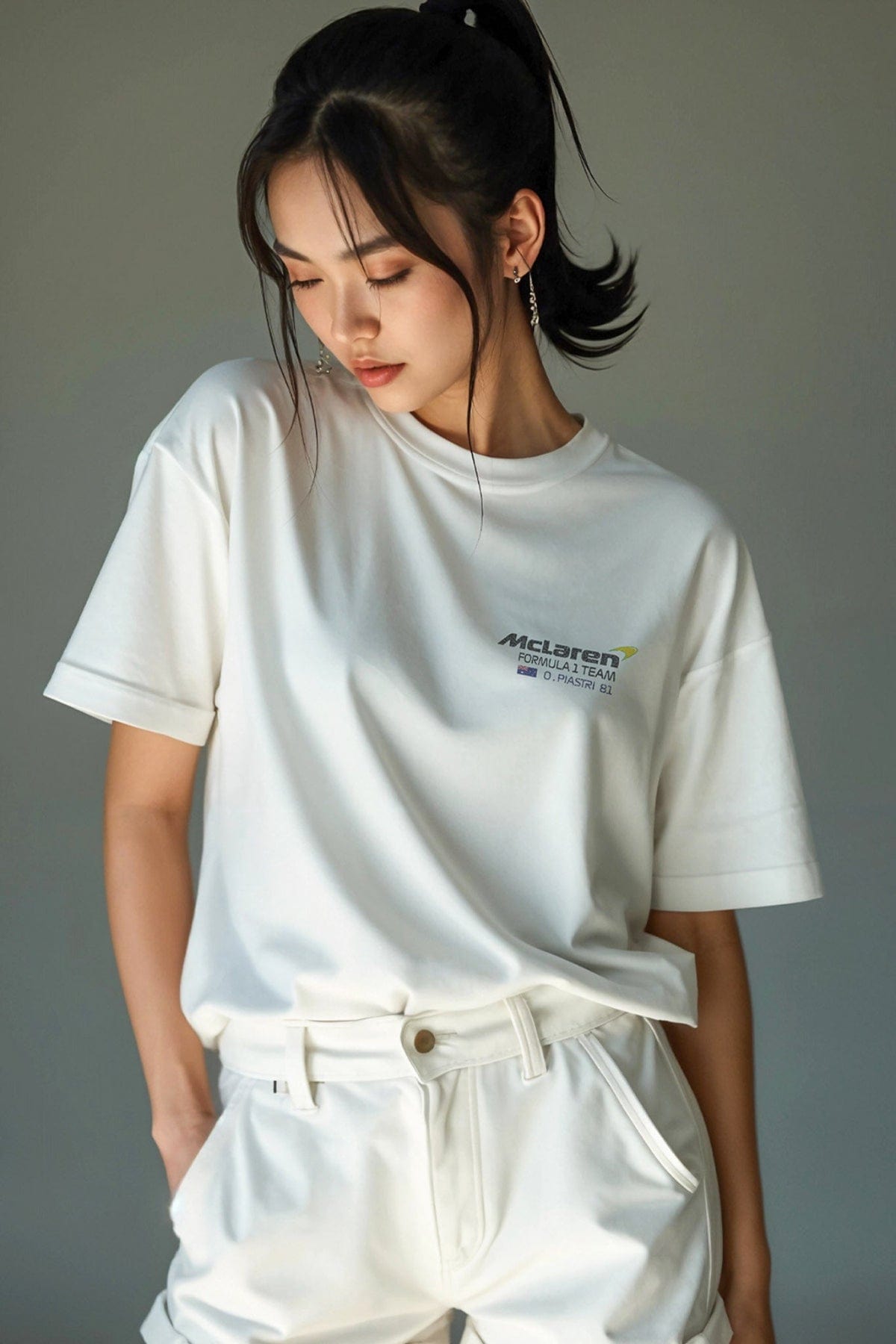 Model wearing a white Mclaren shirt, showcasing the graphic design on the front of the t-shirt.