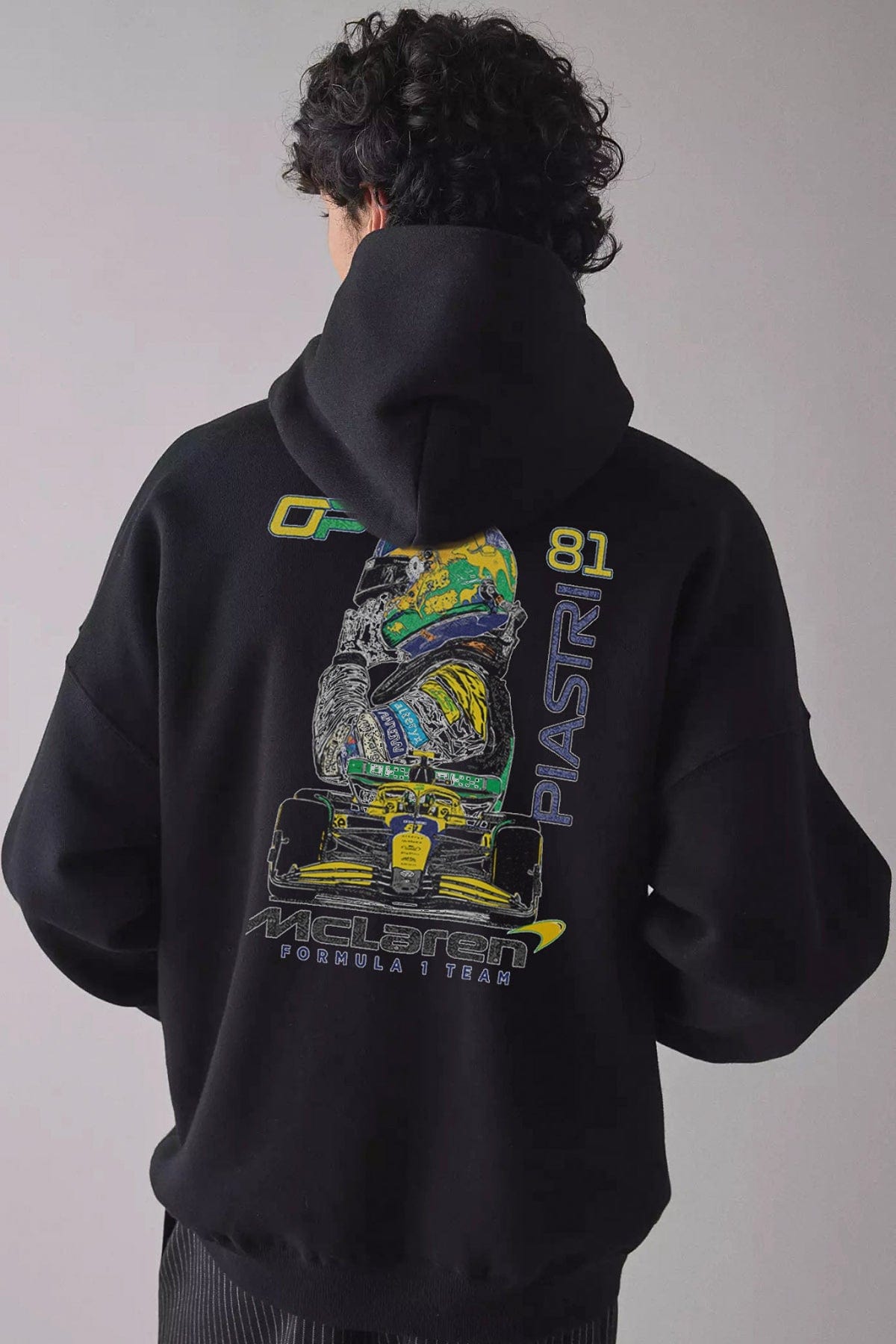 Man wearing a black hoodie, showcasing the design on the back of the custom F1 hoodie.