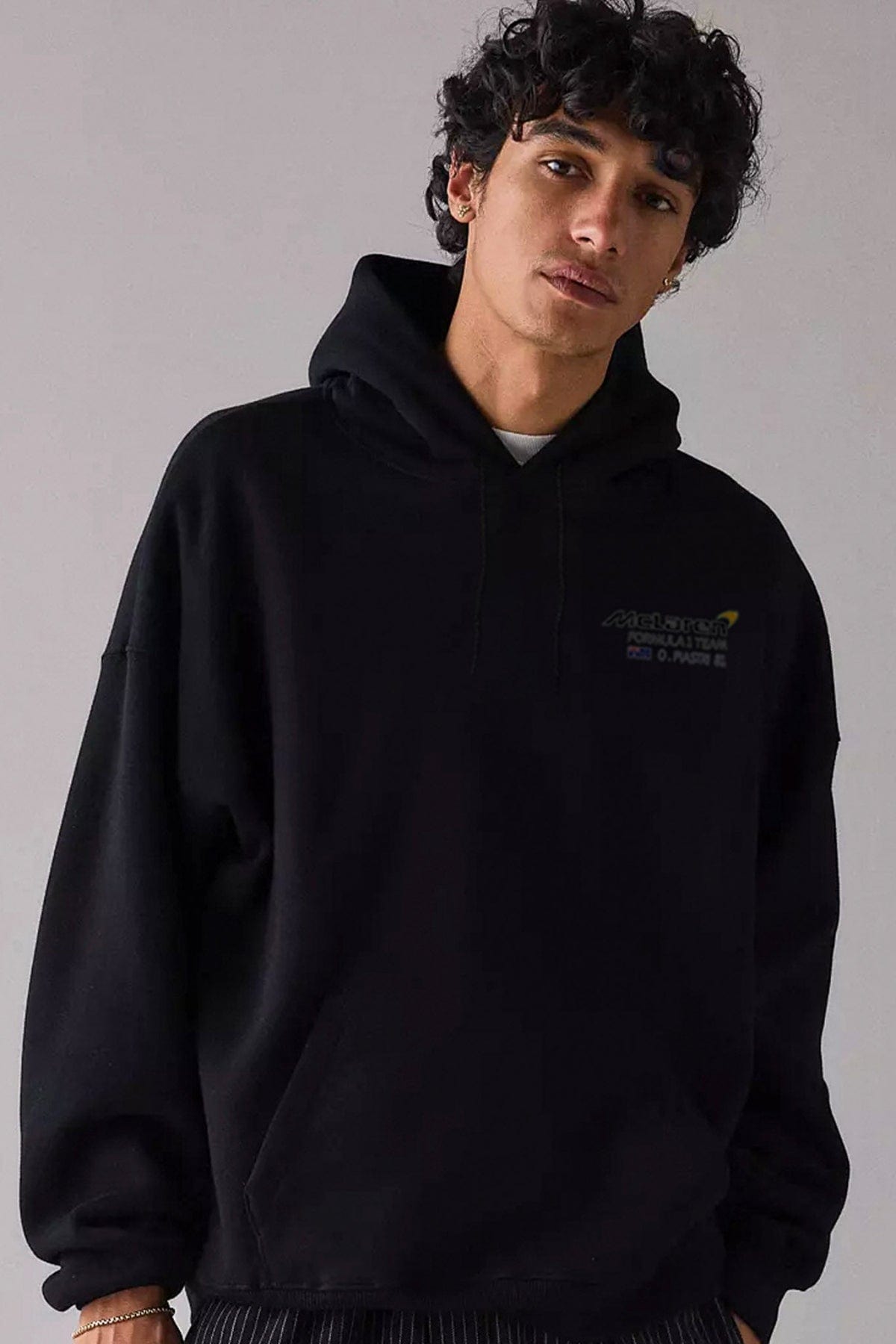 Man wearing a black custom Mclaren F1 hoodie.