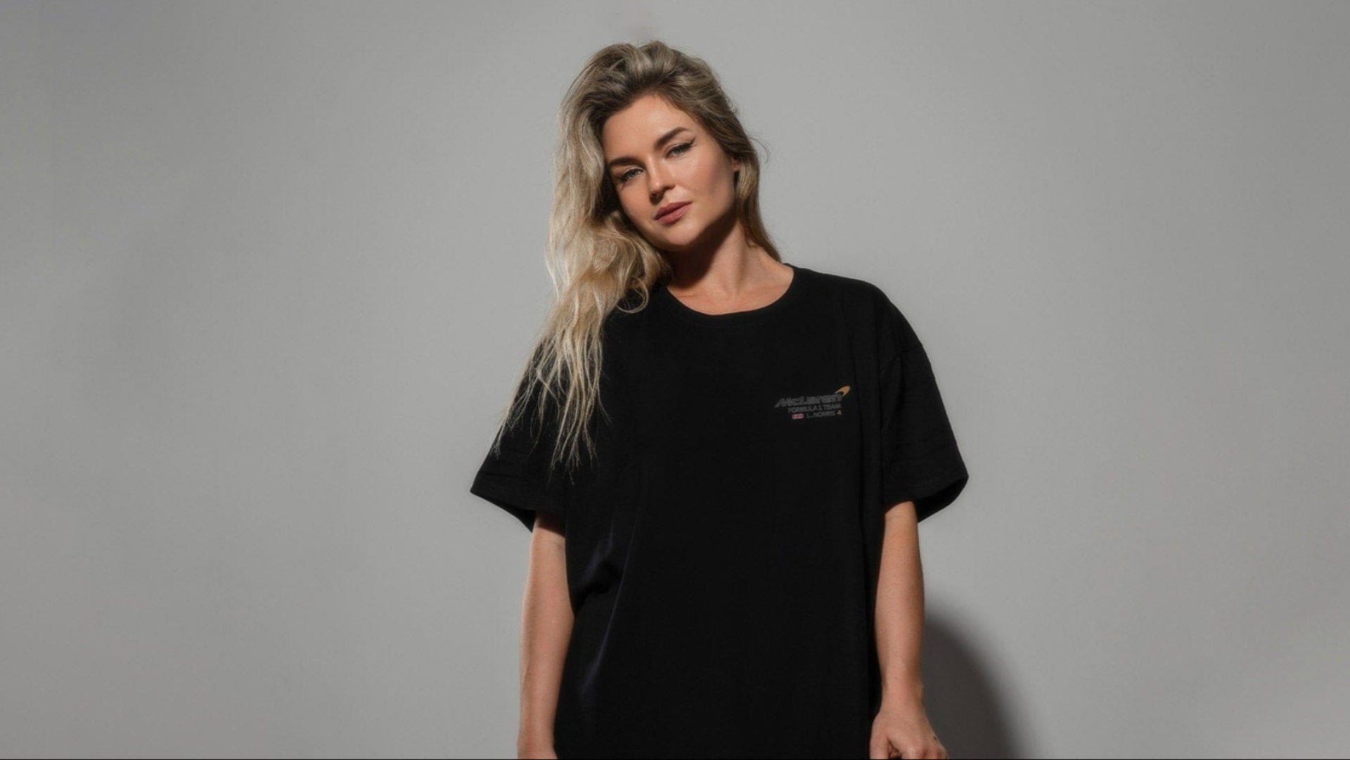 Woman wearing a black t-shirt featuring Utmost Province custom Mclaren F1 geaphic design on the front.