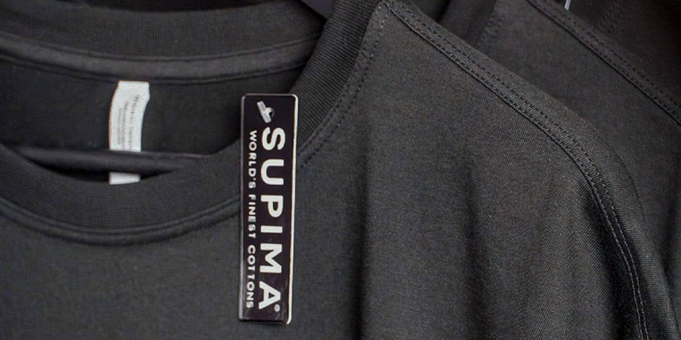 Close up of a black Supima Cotton t-shirt on a hanger.
